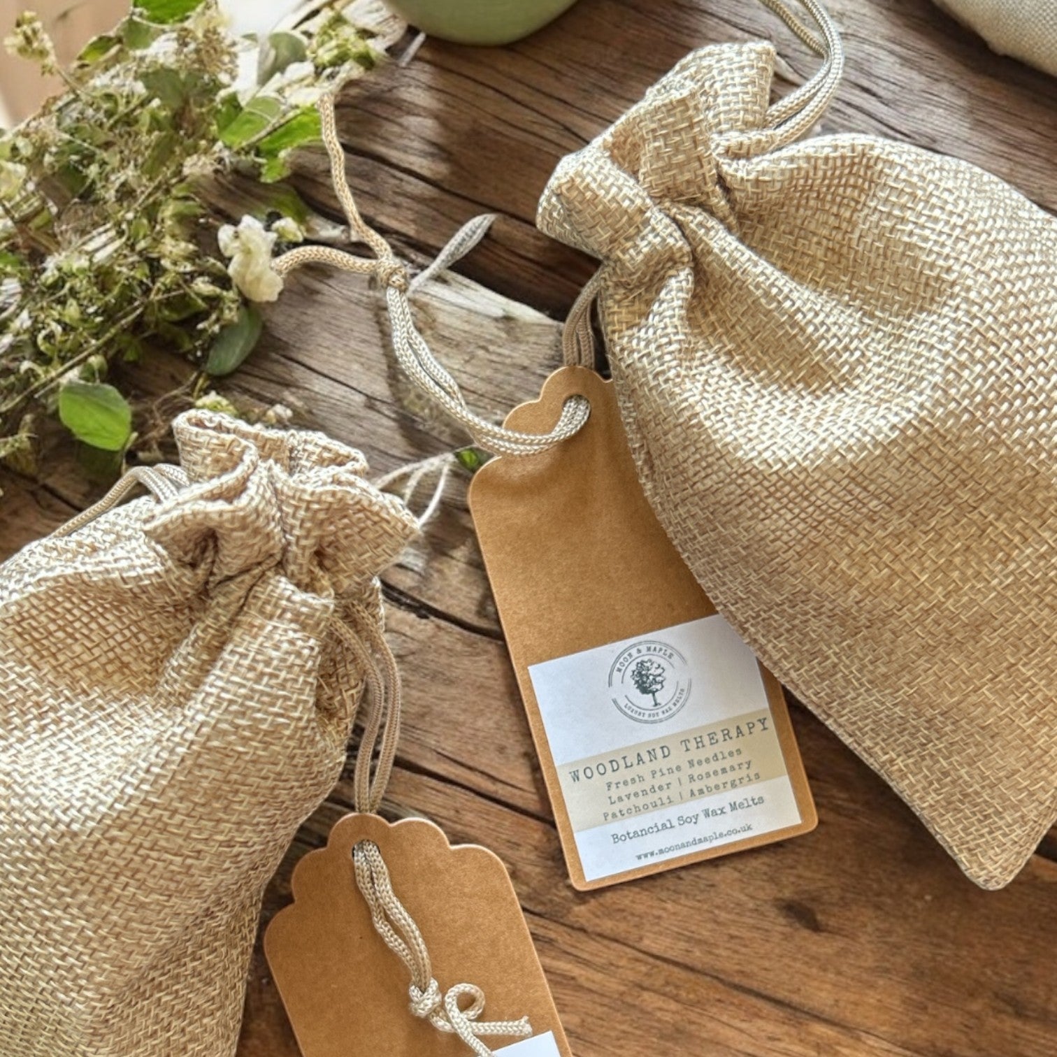 Burlap bags with tags on a wooden surface