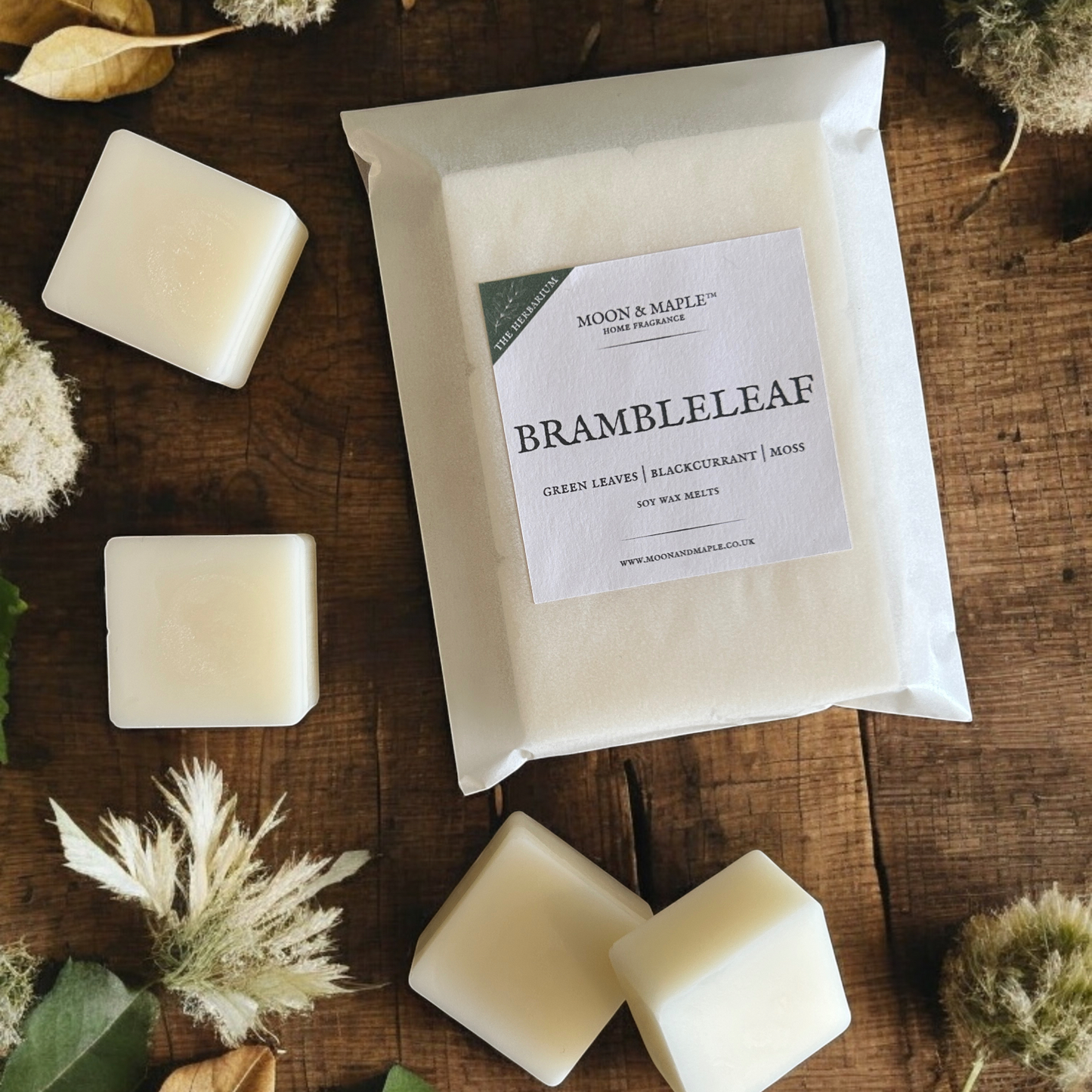 Packaged wax melts with 'Brambleleaf' scent on a wooden surface with decorative elements.