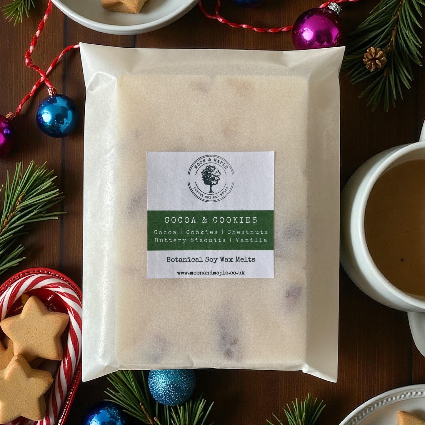 Cocoa & Cookies Soy Wax Melts packaging surrounded by festive decorations and biscuits.