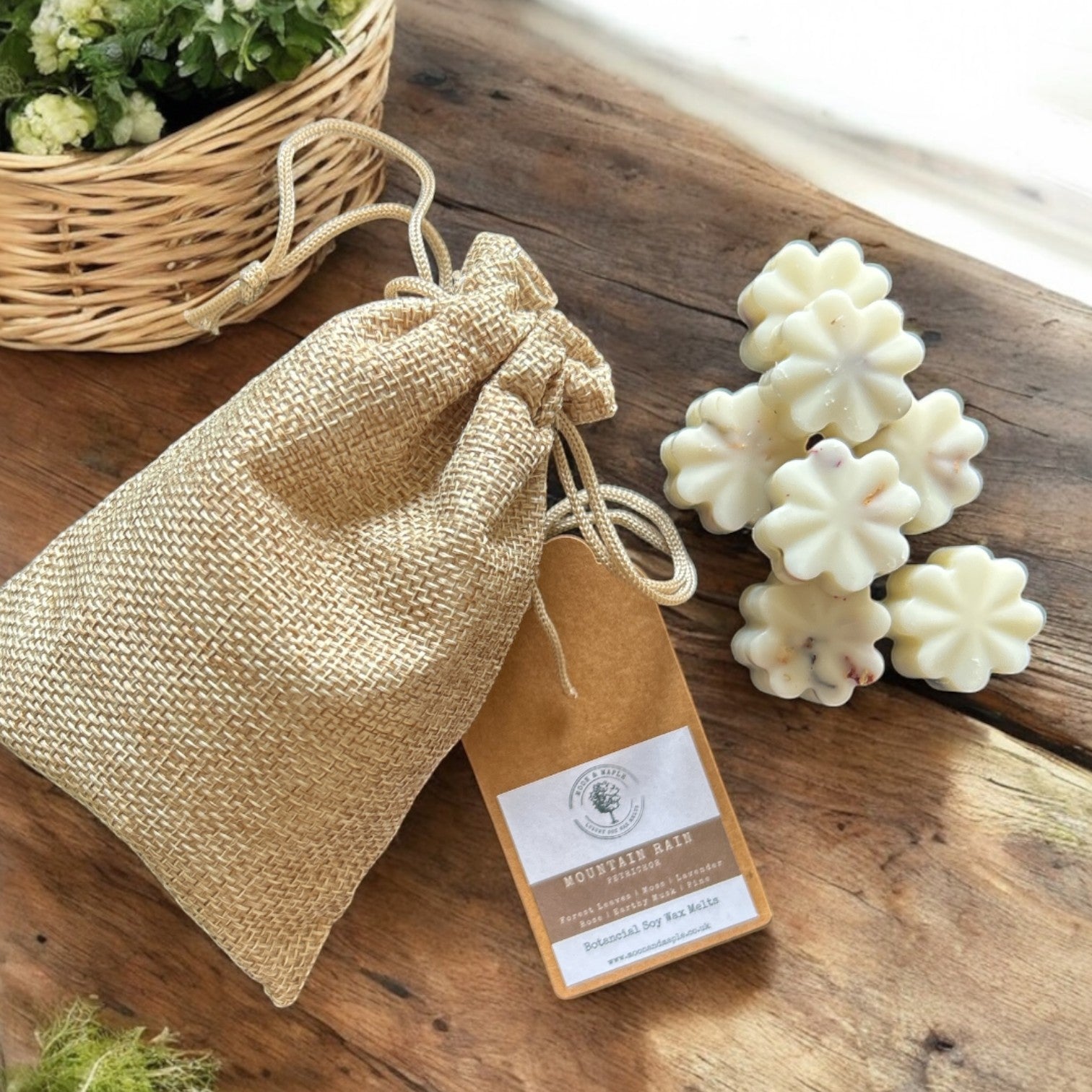 Flower-shaped wax melts on a wooden surface with a burlap bag and label.