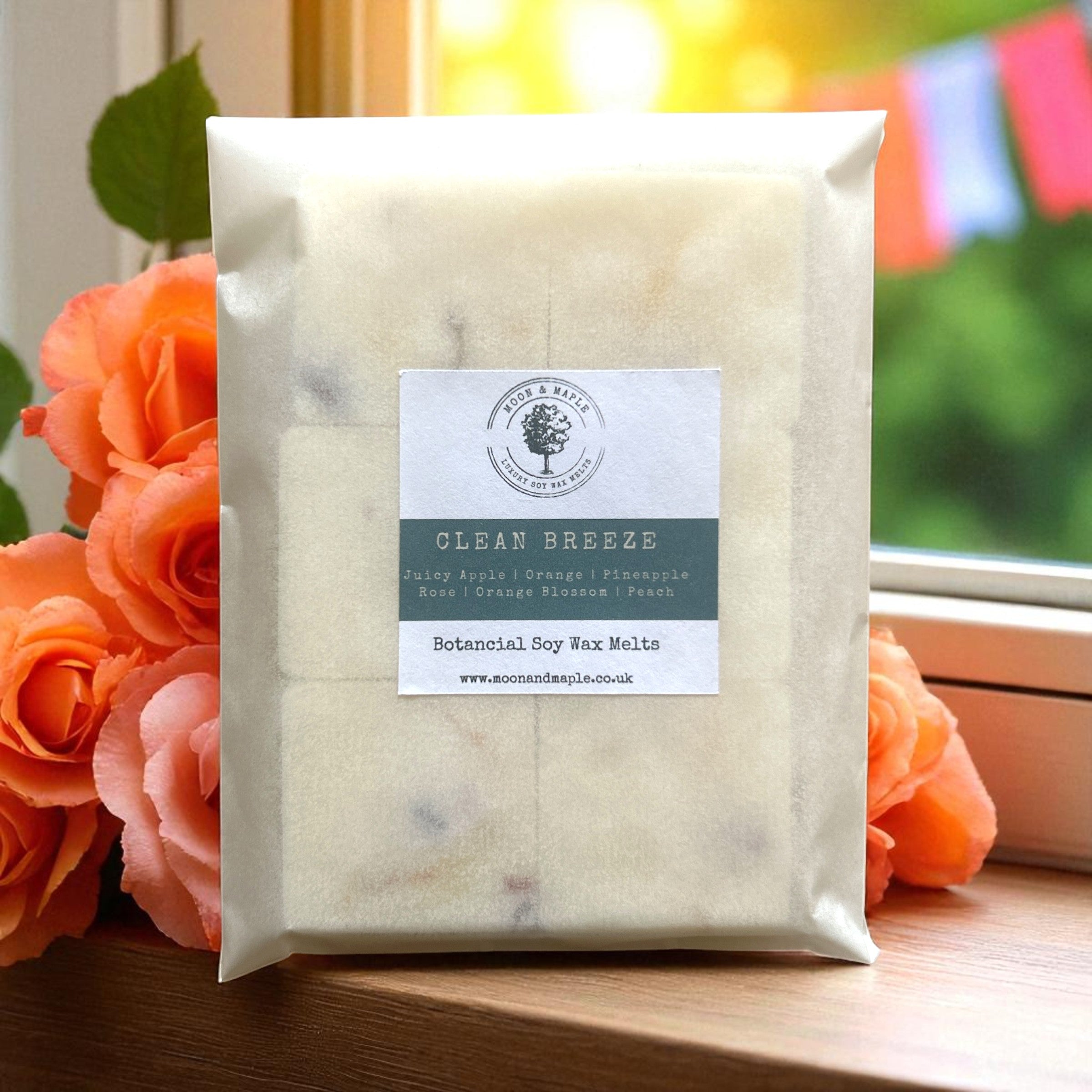 Pack of botanical soy wax melts with a label, surrounded by flowers on a wooden surface.