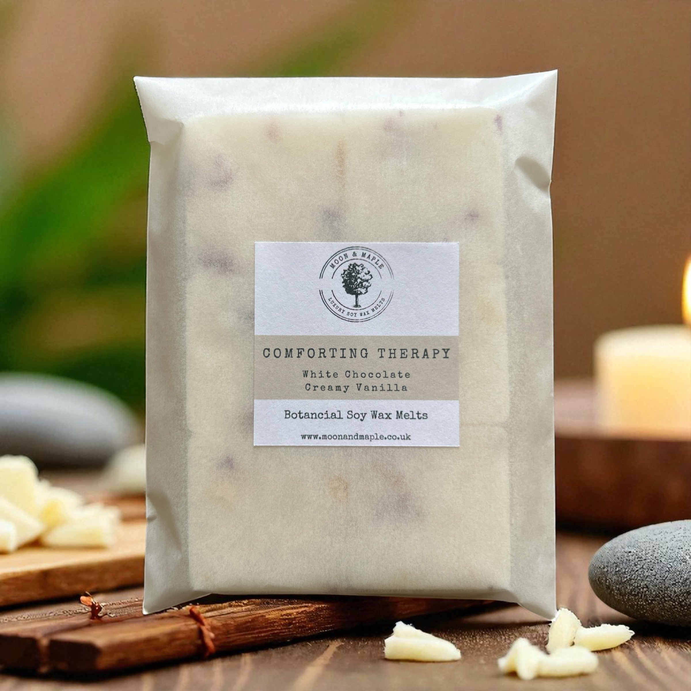 Packaged product with a label on a wooden surface, surrounded by white chocolate pieces and stones.