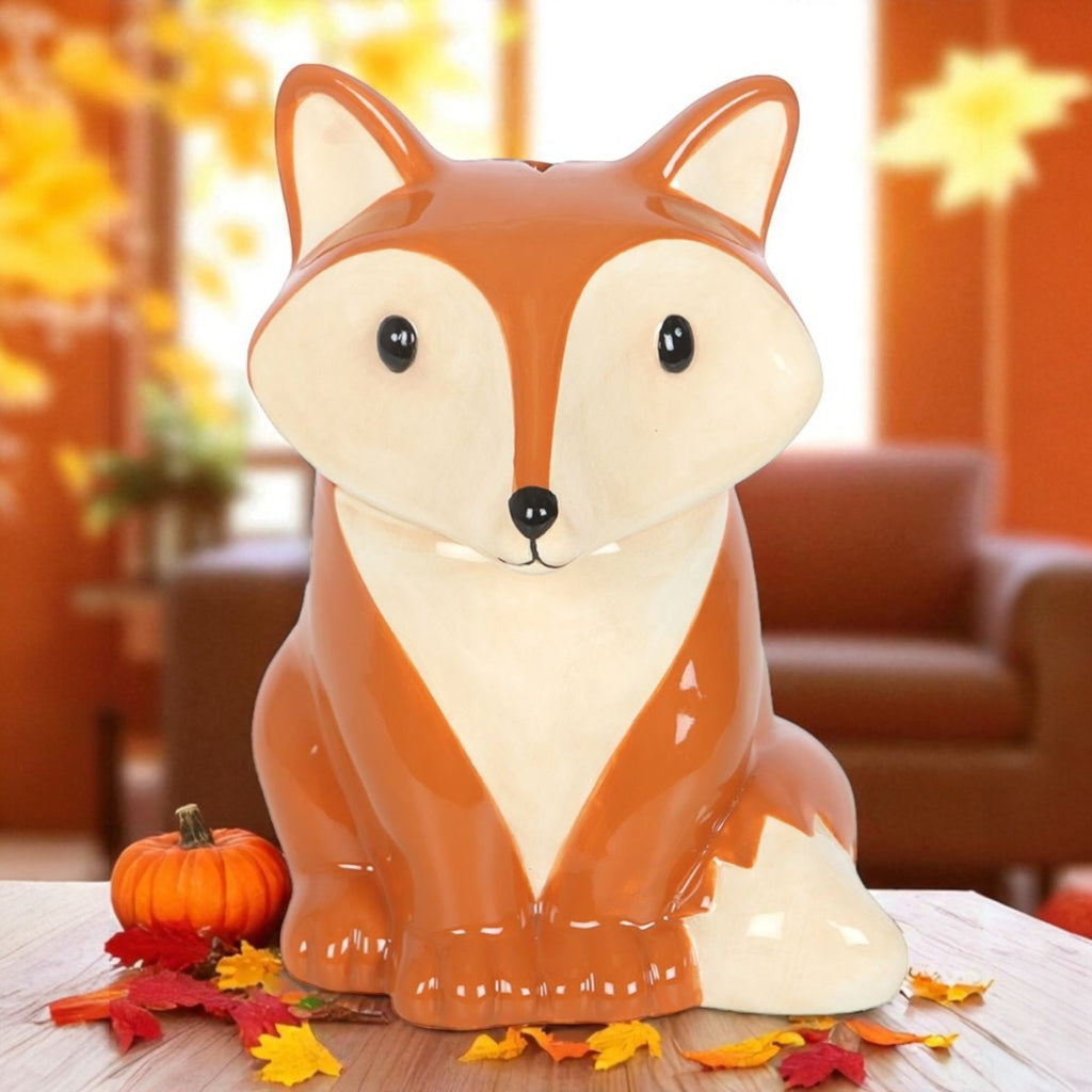 Fox-shaped ceramic wax burner on a table with autumn decorations