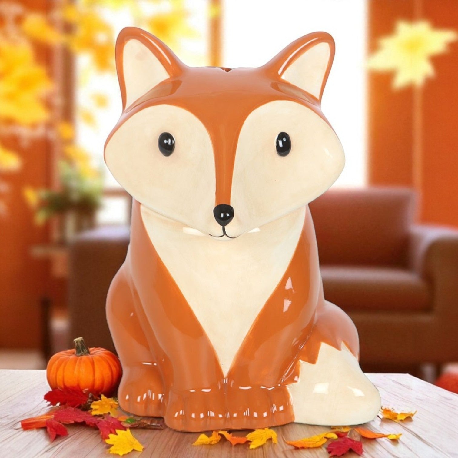 Fox-shaped ceramic wax burner on a table with autumn decorations