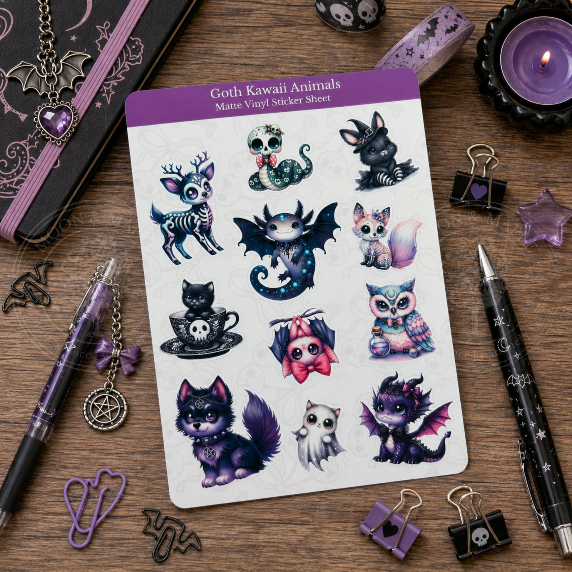 Sheet of goth kawaii animal stickers on a wooden surface with stationery items.