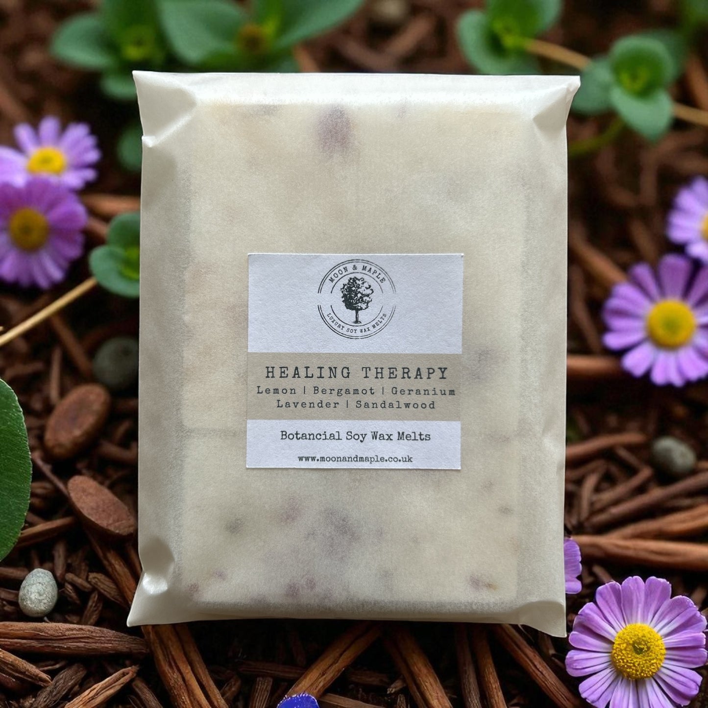 Pack of healing therapy wax melts with a label on a natural background with flowers.