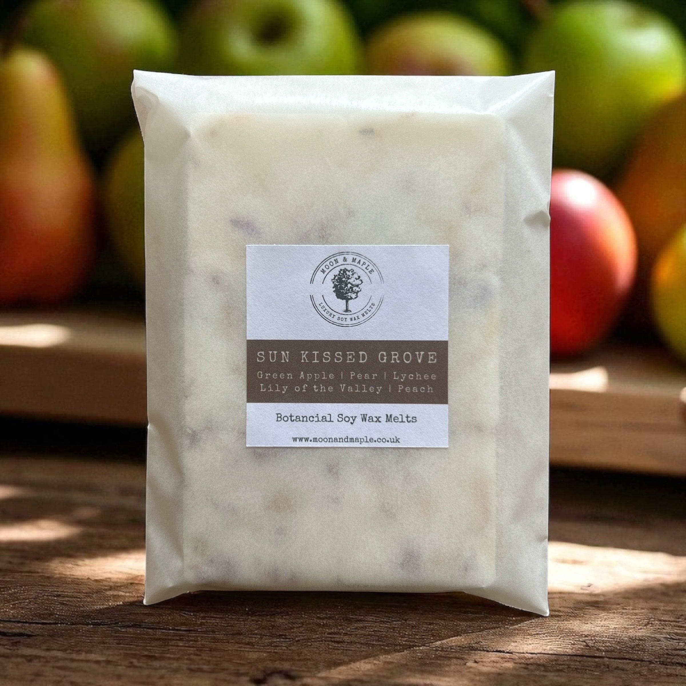 Wax melt package labeled 'Sun Kissed Grove' with apples in the background