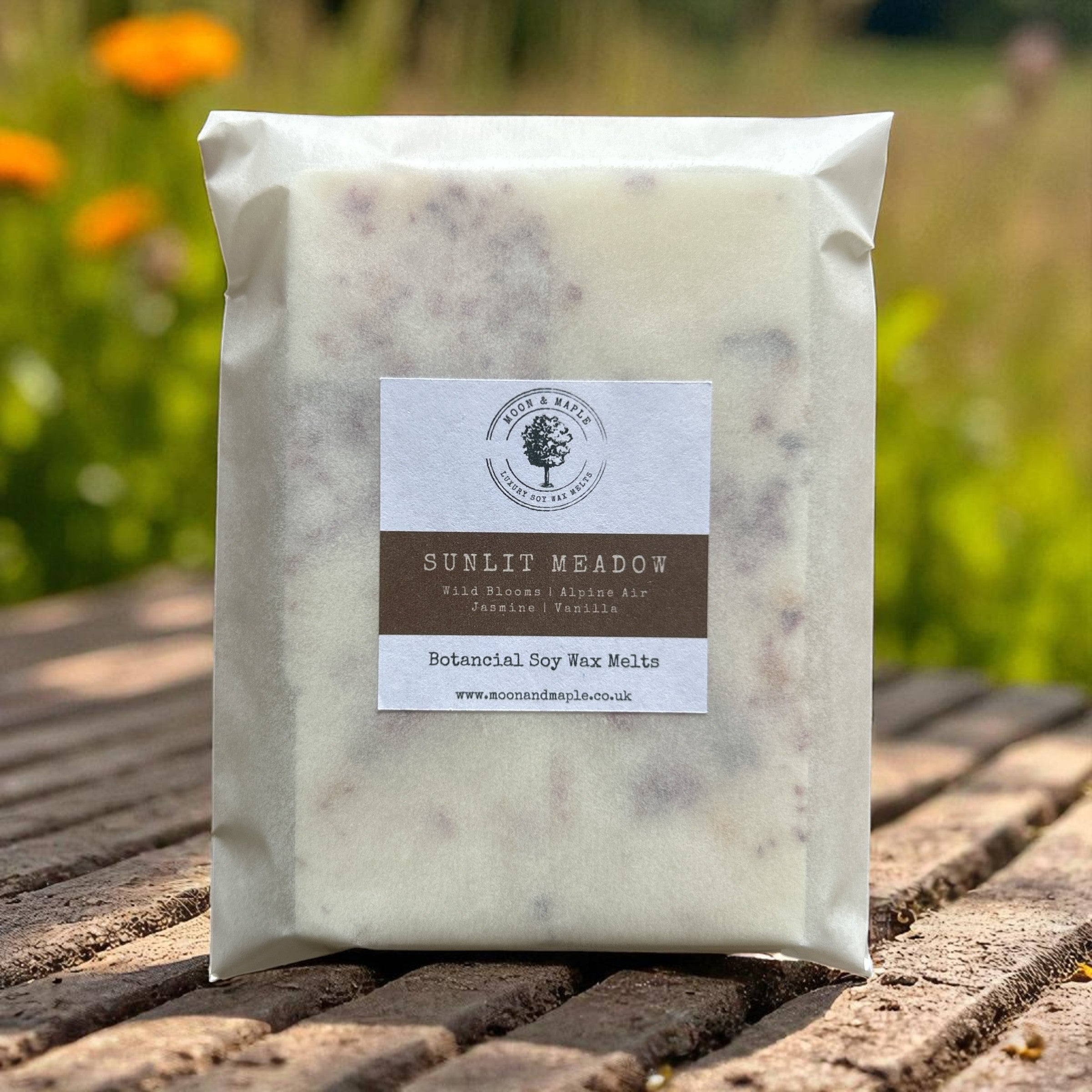 Pack of Sunlit Meadow wax melts on a wooden surface with a blurred natural background