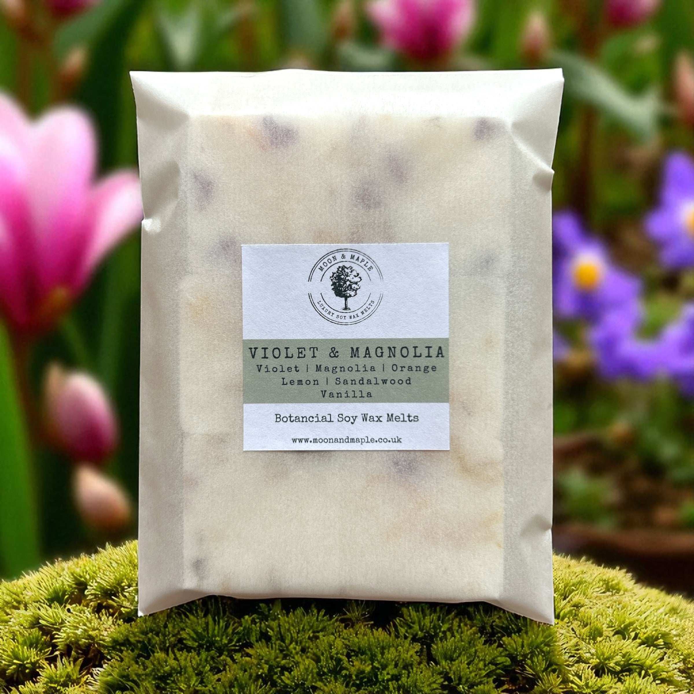 Pack of Violet & Magnolia wax melts on a green background with flowers