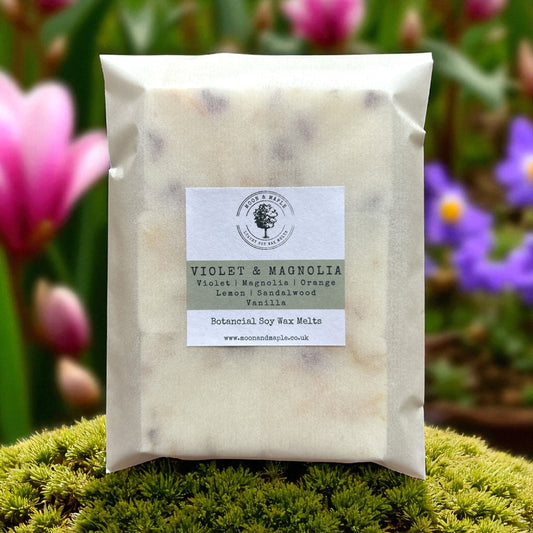 Pack of Violet & Magnolia wax melts on a green background with flowers