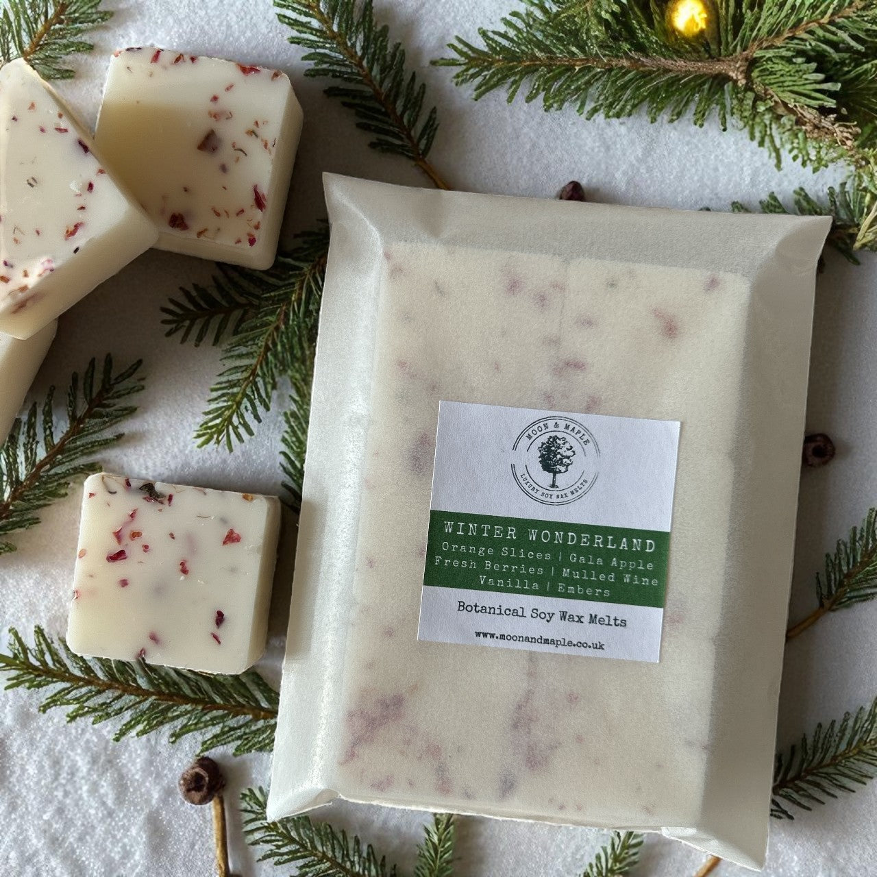 Winter Wonderland Soy Wax Melts - The Christmas Collection with orange slices and berries, surrounded by pine branches.