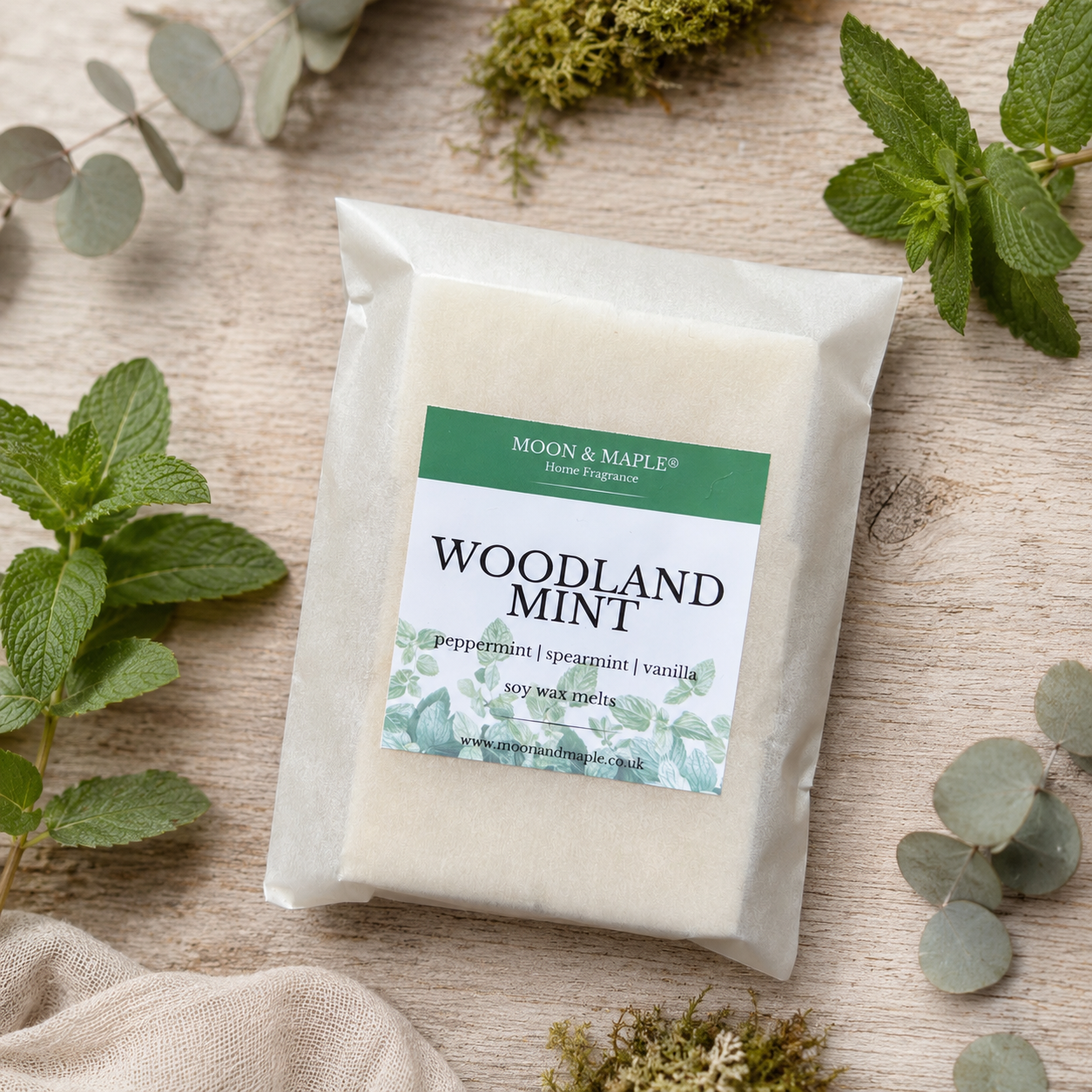 Moon & Maple Woodland Mint wax melts on a wooden surface with greenery