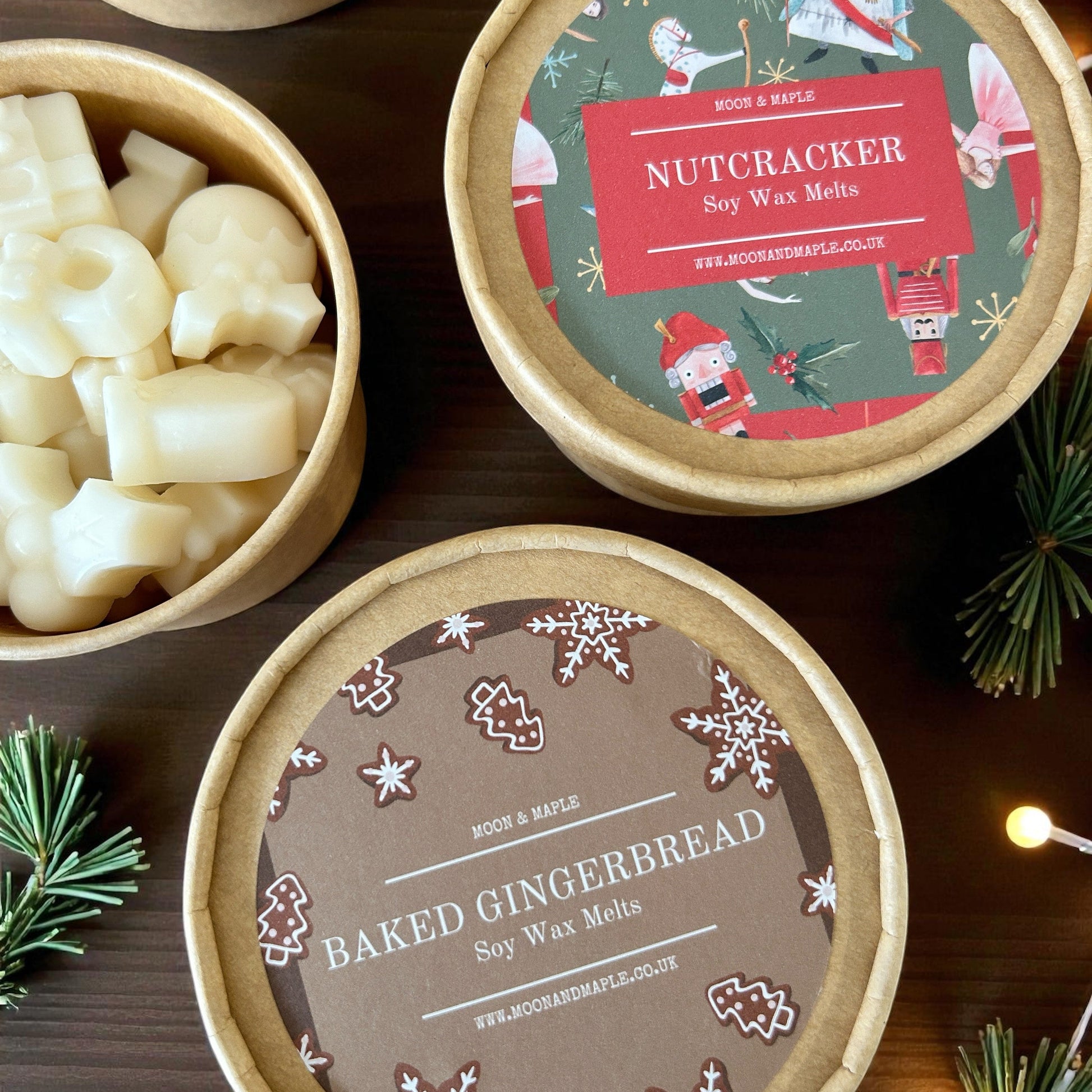 Soy wax melts in decorative tins with Christmas-themed labels on a wooden surface.